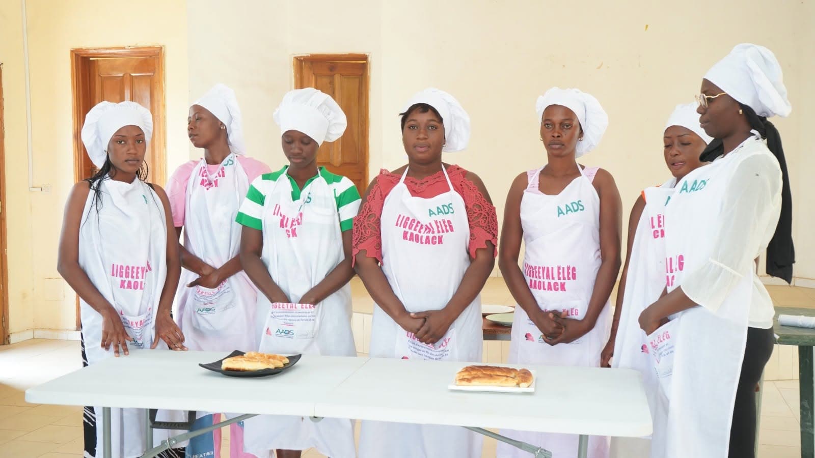 Participantes d'un GIE de Kaolack en tenue de formation lors d'une session de pâtisserie du projet LIGGEEYAL ËLËG, supervisée par l'AADS